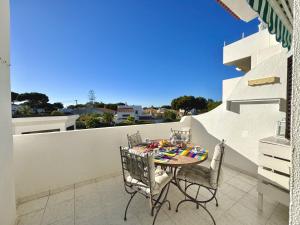 a patio with a table and chairs on a balcony at Vilamoura Brightness Apartment with Pool by Homing in Vilamoura