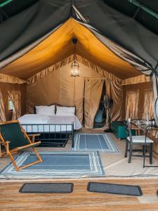 a tent with a bed and a table and chairs at Streaming Offline Karjat - Premium Tent Stay with Private Plunge Pool in Jambrung 