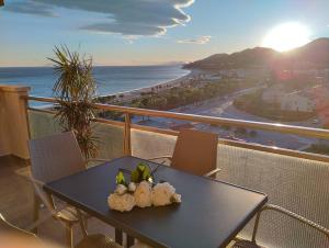 a table on a balcony with a view of the ocean at Apartamento con terraza, vistas playa y montaña in Hospitalet de l'Infant