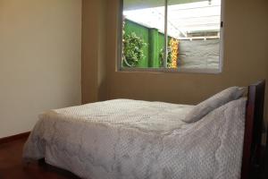 a bedroom with a bed and a window at Departamento La República in Cuenca