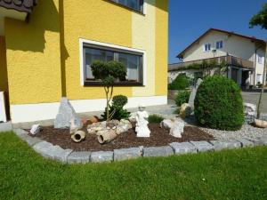 un jardin avec des animaux empaillés dans l'herbe devant une maison dans l'établissement Ferienwohnung Simon In Gleißenberg, à Gleißenberg