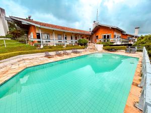 a swimming pool in front of a house at Plaza Inn Week Inn in Campos do Jordão
