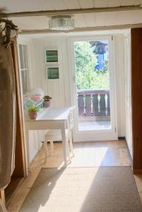a room with a white table and a balcony at Casa Marili, Das Charmante Ferienhaus in Seewis