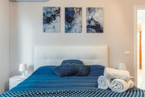 um quarto com uma cama azul com quatro fotografias na parede em Raf Rhome Seaside - Center 200m to the Sea em Lido di Ostia