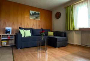 Una sala de estar con un sofá azul y una mesa. en Obererli, en Hasliberg 13 fotos más