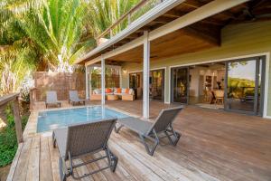 a deck with chairs and a pool on a house at Tesoro en la Colina in Palmetto Bay