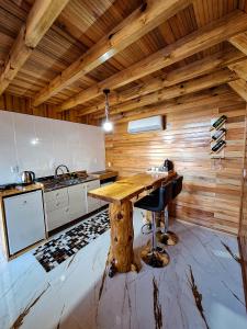 a kitchen with a wooden ceiling and a wooden table at Cabanas Céu e Mel - Cabana 01 in Bom Retiro