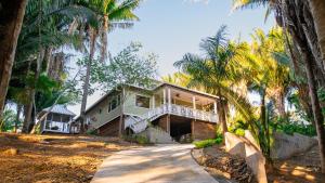 a house with palm trees in front of it at Tesoro en la Colina in Palmetto Bay