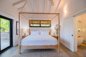 a bedroom with a canopy bed and a tub at Tesoro en la Colina in Palmetto Bay +36 photos