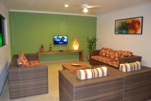 a living room with two couches and a tv at Pousada Beija Flores in Porto De Galinhas