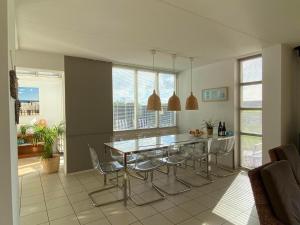 ein Esszimmer mit Glastisch und Stühlen in der Unterkunft Luxus-Villa, zu Fuß zum Strand, Dünenansicht mit privatem Whirlpool in Julianadorp