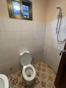 a bathroom with a toilet and a window at Brimelia Lodge  +15 photos