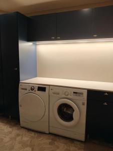 a washer and dryer in a kitchen with black cabinets at Villa Kontio in Rovaniemi