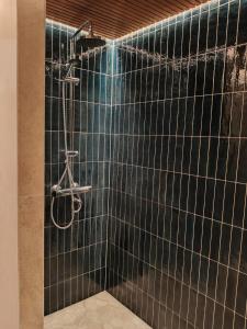a bathroom with a black tiled wall with a shower at Villa Kontio in Rovaniemi +24 photos