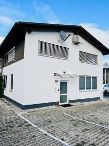 a white house with a parking lot at Haus Ambiente - 4 Fewos in Bad Säckingen