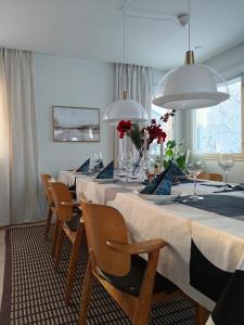 a dining room with a table with chairs and wine glasses at Villa Kontio in Rovaniemi