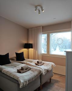 two beds in a room with a window at Villa Kontio in Rovaniemi