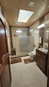a bathroom with a shower and a toilet and a sink at Casa campestre cerca de termales con WiFi y parqueadero in Santa Rosa de Cabal