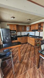 a kitchen with wooden cabinets and a wooden floor at Casa campestre cerca de termales con WiFi y parqueadero in Santa Rosa de Cabal +9 photos