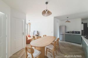 eine Küche und ein Esszimmer mit einem Holztisch und Stühlen in der Unterkunft Room in spacious T7 in Paris 20 in Paris