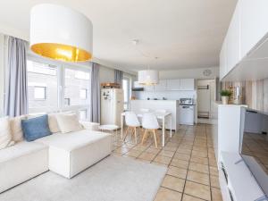 Una sala de estar con un sofá blanco y una cocina. en Kwintebank - 0904, en Miami Wijk