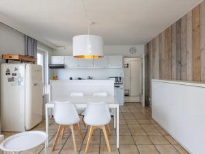 cocina con mesa blanca y sillas blancas en Kwintebank - 0904, en Miami Wijk