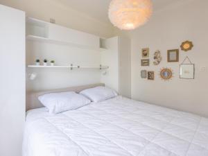 Una habitación blanca con una cama grande con sábanas blancas. en Kwintebank - 0904, en Miami Wijk