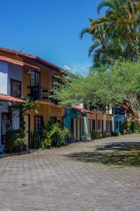 a row of houses with a palm tree in front at Casa em condomínio com piscina in Paraty