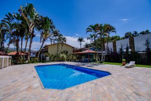 a swimming pool in a yard with palm trees at Casa em condomínio com piscina in Paraty