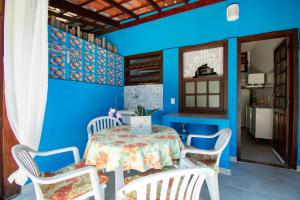 a blue dining room with a table and chairs at Casa em condomínio com piscina in Paraty