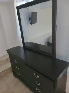 a black dresser with a mirror on top of it at Blue Sail Apartments in Simpson Bay