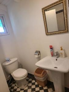 a bathroom with a white toilet and a sink at Blue Sail Apartments in Simpson Bay