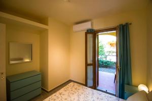 a bedroom with a door leading to a patio at Quadrilocale Stella in Alberese