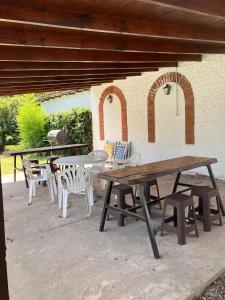 - un ensemble de tables de pique-nique et de chaises sur une terrasse dans l'établissement Valle De Las Sierras Hotel, à La Falda