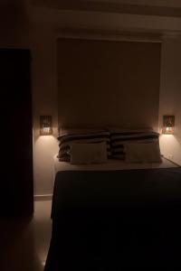 a bedroom with a bed with two lights on it at Apartamento 100m da praia in Conde