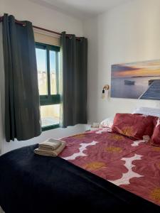 a bedroom with a large bed with a large window at Vega Maspalomas - Escapada de sol, piscina y relax in San Bartolomé +16 photos