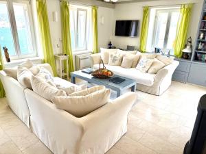 ein Wohnzimmer mit weißen Sofas und einem Tisch in der Unterkunft JASMINE VILLA luxury house with private pool, spacious terraces and spectacular sea views in Vis
