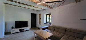 un salon avec un canapé et une télévision dans l'établissement Ciechówka, à Wilimy