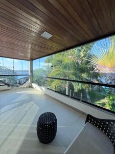 une pièce avec un banc devant une grande fenêtre dans l'établissement Casa com Deck e Acesso ao Rio Espaço para Barco 4 Suítes e Área Gourmet, à Aracaju