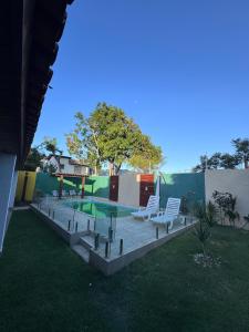 un patio avec deux chaises et une piscine dans l'établissement Casa com Deck e Acesso ao Rio Espaço para Barco 4 Suítes e Área Gourmet, à Aracaju