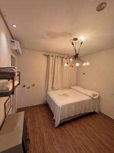 une chambre avec un lit et un lustre dans l'établissement Casa com Deck e Acesso ao Rio Espaço para Barco 4 Suítes e Área Gourmet, à Aracaju 4 autres photos