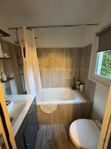 une salle de bain avec une baignoire, un lavabo et des toilettes dans l'établissement Studio with pool and quiet, non-shared garden, à Gardanne