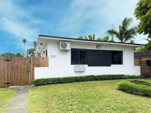 a white house with a fence in a yard at Unit 1 Cozy 1BR Apt with Parking in Miami
