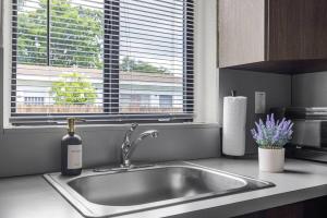 a kitchen sink with a bottle of wine next to a window at Unit 1 Cozy 1BR Apt with Parking in Miami +22 photos