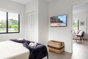 a bedroom with a bed and a tv on a wall at Unit 1 Cozy 1BR Apt with Parking in Miami