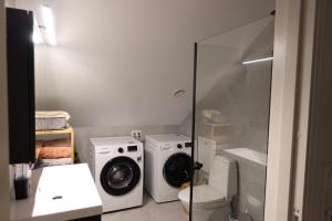 une salle de bain avec une machine à laver et un lave-linge dans l'établissement HomeSuite Room,  1 autre photo
