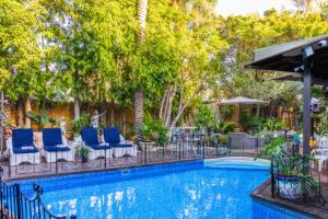 a swimming pool with blue lounge chairs and trees at Luxury Stay Villa de Caesarea in Caesarea