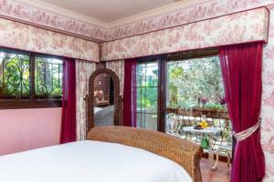 a bedroom with a bed with red curtains and windows at Luxury Stay Villa de Caesarea in Caesarea