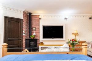 a bedroom with a bed with a television and a fireplace at Luxury Stay Villa de Caesarea in Caesarea