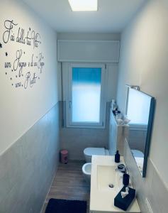 a bathroom with a toilet and a sink and a mirror at Treviso Home Chic in Treviso